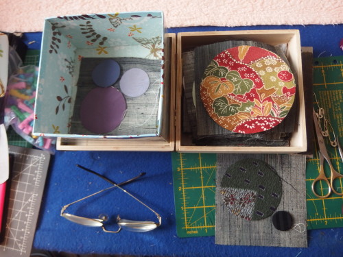 Box of circles cut out waiting to be hemed then applqiued on to the tiny squares. 