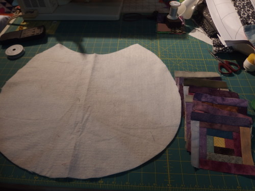 A backing shape cut out and wadding in cotton, Ive made 14,  4 inch log-cabins 