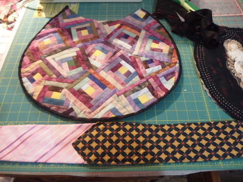 Binding sewn on and two ties waiting to be sewn together by machine. 