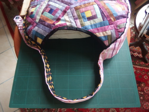 ties come up and over lap each other and form the handle for the bag, by echo quilting the ties they are more firm, stable, and don't scrunch up in the hand when carrying it. 