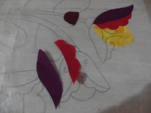 Building up the irononfusing flowers, ironing them on to a Teflon sheet which is over the pattern to guide me. 