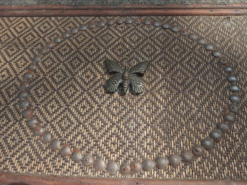 close up of the basket weaving and brass butterfly. 