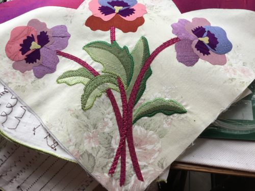 Finally have my machine again after 6 weeks of no sewing machine, working on appliqueing down my pansy blocks 